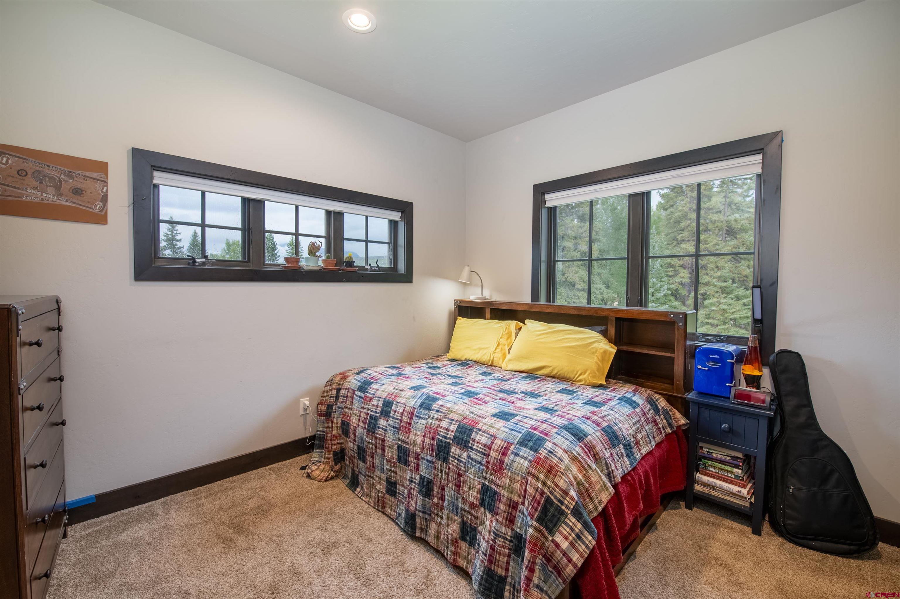 23 Jacquelyn Lane Crested Butte, CO 81224 - Photo 22 of 33 a bedroom with a bed a dresser and a window