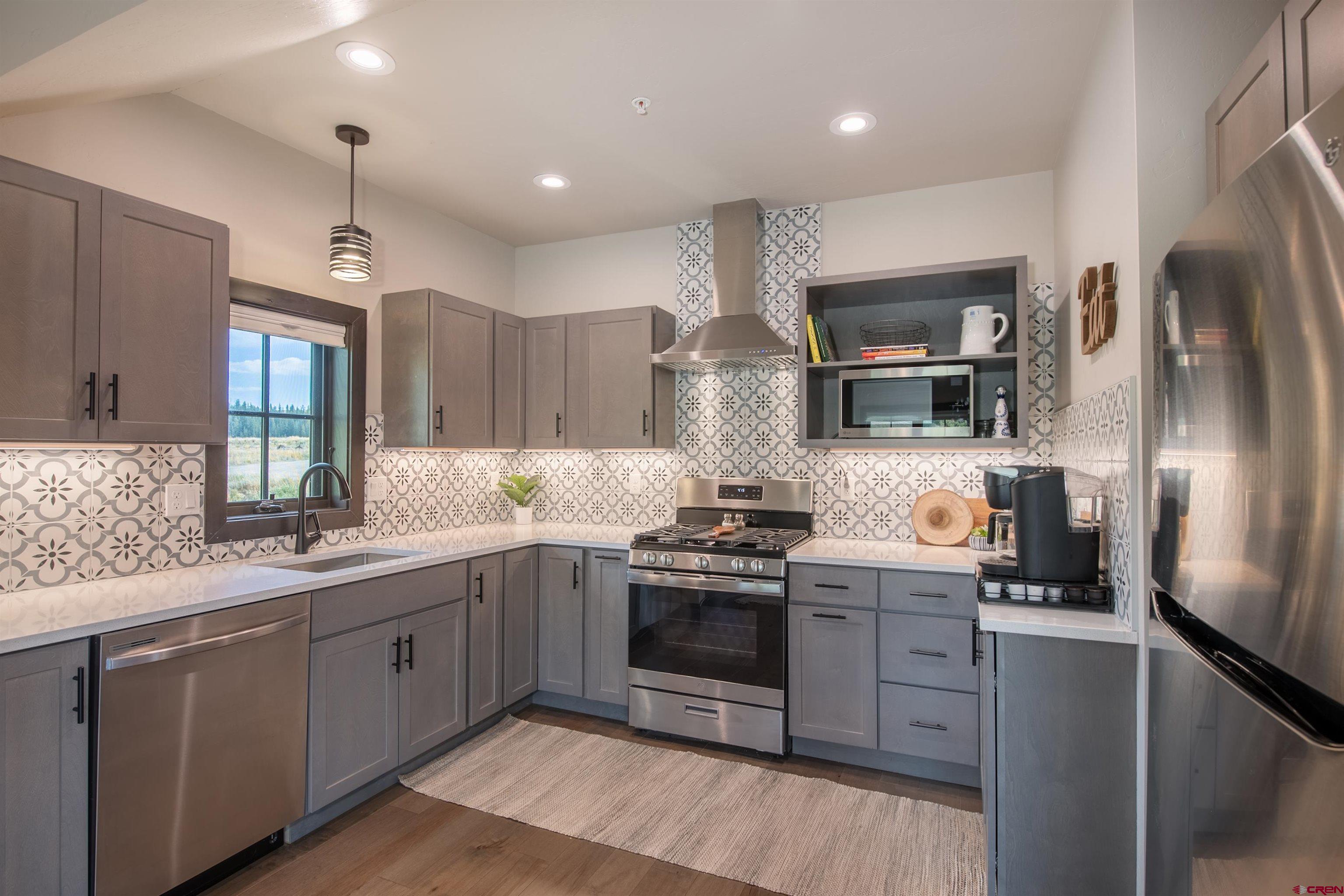 23 Jacquelyn Lane Crested Butte, CO 81224 - Photo 29 of 33 a kitchen with stainless steel appliances granite countertop a stove a sink dishwasher a refrigerator and a oven with wooden floor