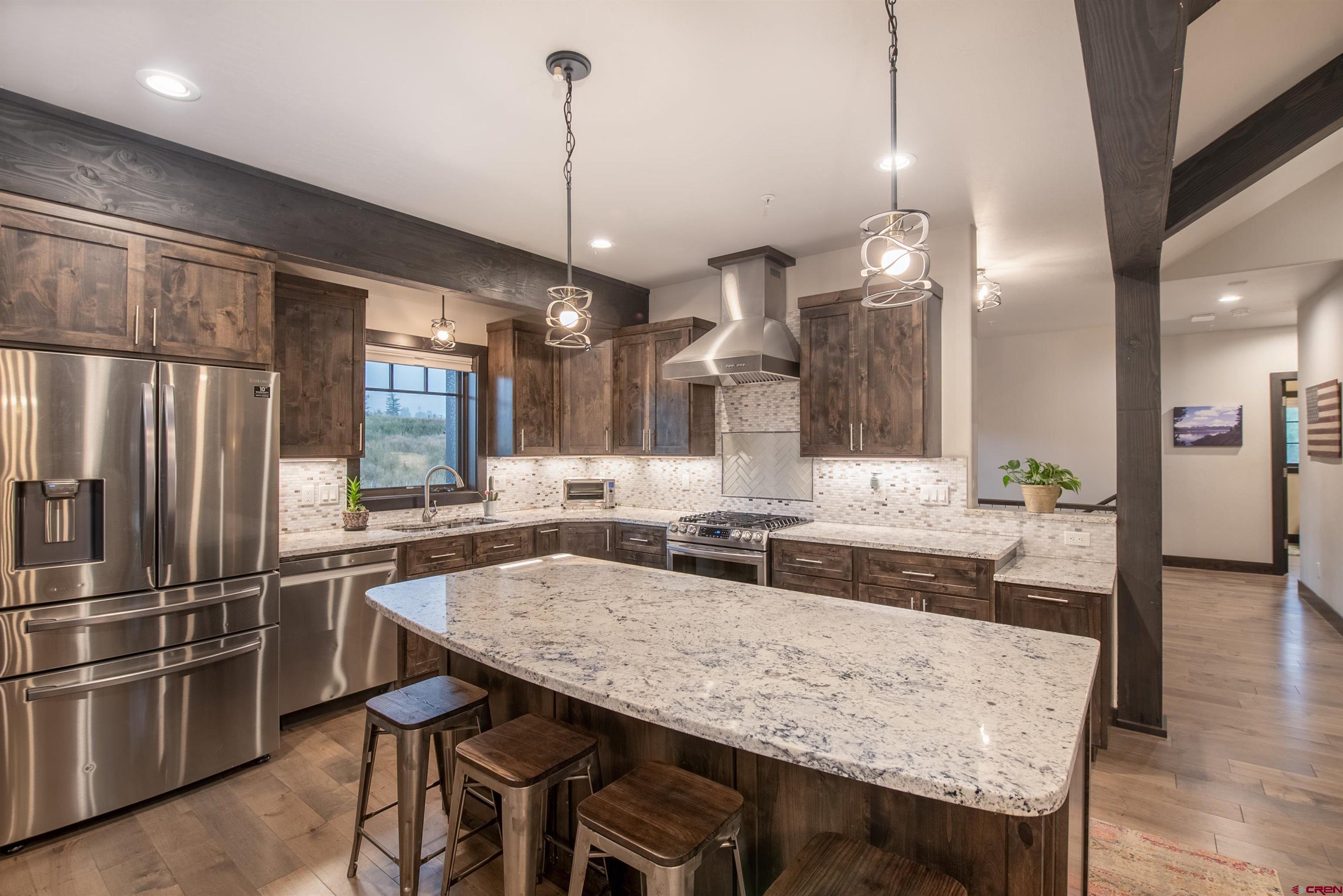 23 Jacquelyn Lane Crested Butte, CO 81224 - Photo 10 of 33 a kitchen with stainless steel appliances granite countertop wooden floor dining table and chairs
