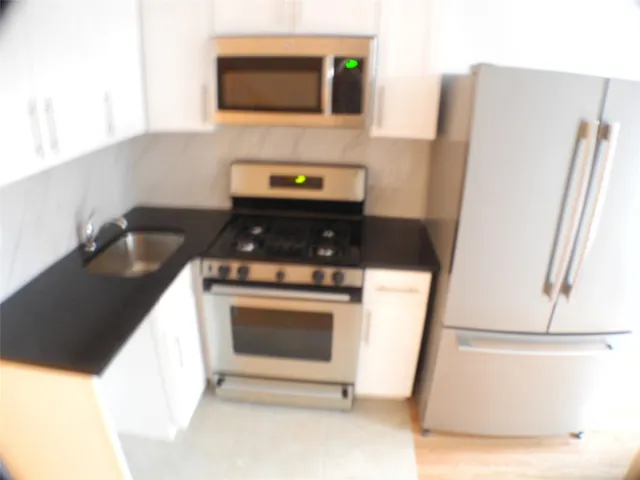 a kitchen with a refrigerator stove and microwave