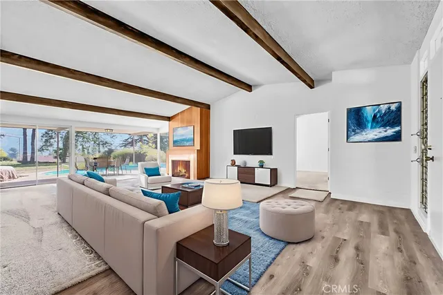 a kitchen with stainless steel appliances granite countertop a refrigerator a sink dishwasher a stove and white countertops with wooden floor