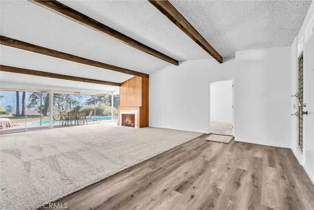 a large kitchen with a stove top oven a sink dishwasher a refrigerator and white cabinets with wooden floor