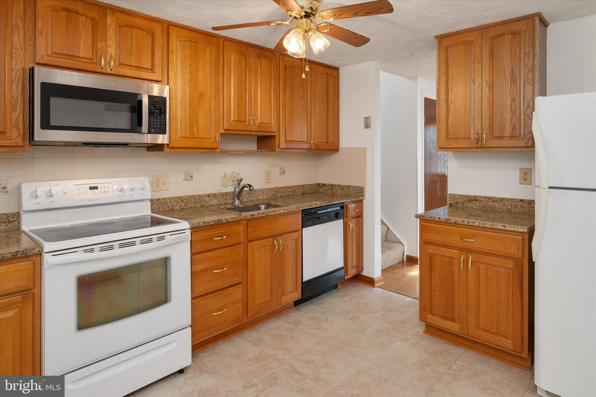 226 Compass Road Baltimore, MD 21221 - Photo 11 of 35 a kitchen with stainless steel appliances granite countertop white cabinets a stove top oven a sink and dishwasher