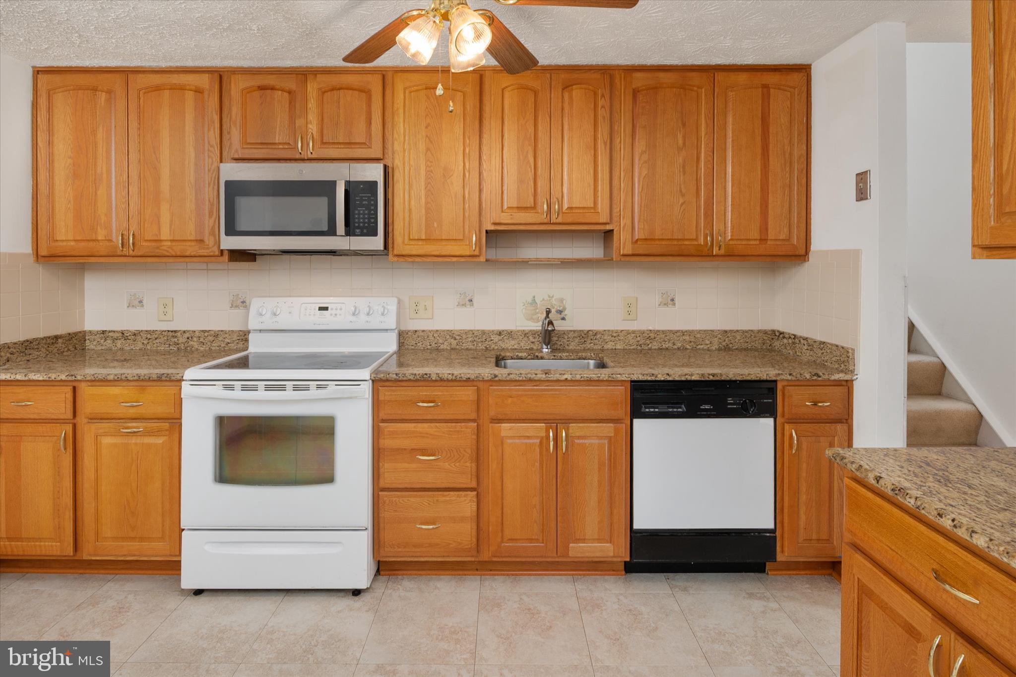 226 Compass Road Baltimore, MD 21221 - Photo 10 of 35 a kitchen with granite countertop white cabinets and white stainless steel appliances