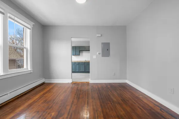 a view of an empty room with wooden floor