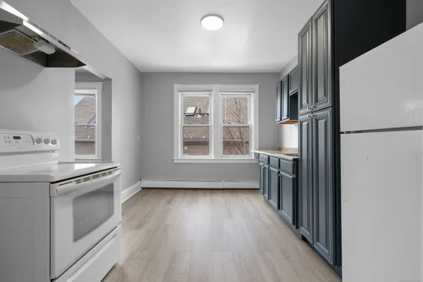 a kitchen with a refrigerator wooden floor and window
