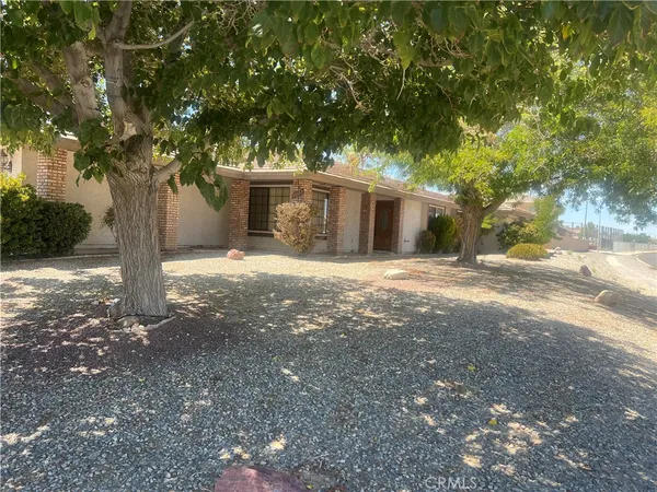 a view of a house with a tree in front of it