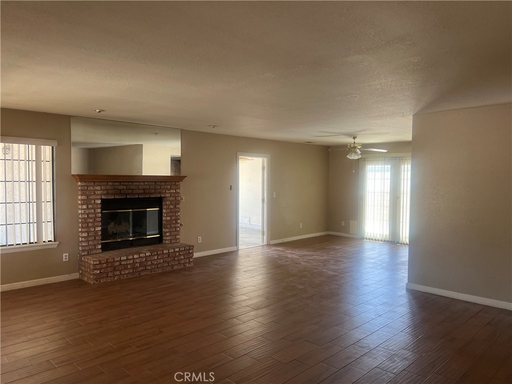 26682 Mainsail Lane Helendale, CA 92342 - Photo 6 of 13 a view of an empty room with wooden floor fireplace and a window
