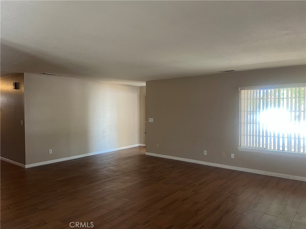 26682 Mainsail Lane Helendale, CA 92342 - Photo 7 of 13 an empty room with wooden floor and windows