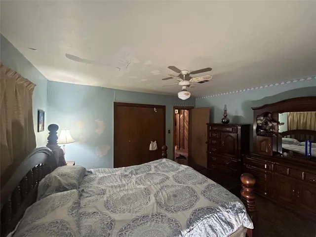 a bedroom with a bed dresser and a flat tv screen