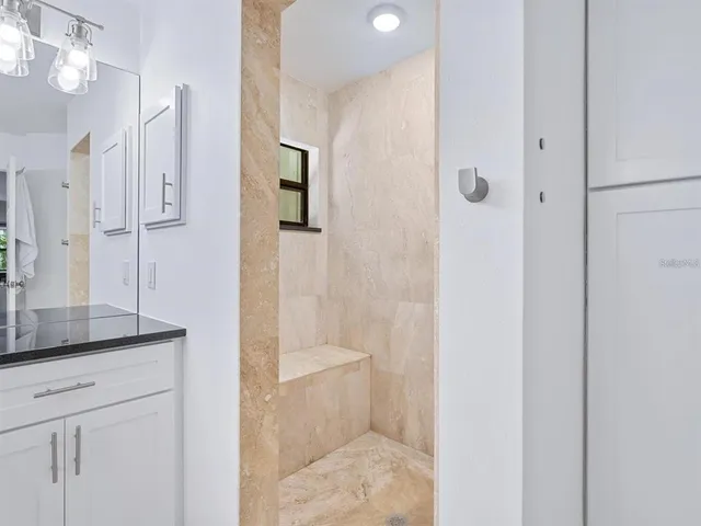 a bathroom with a shower sink and mirror