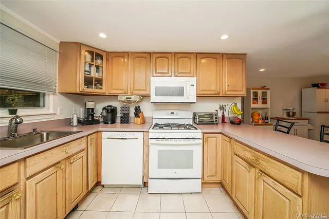a kitchen with cabinets appliances a sink and a window