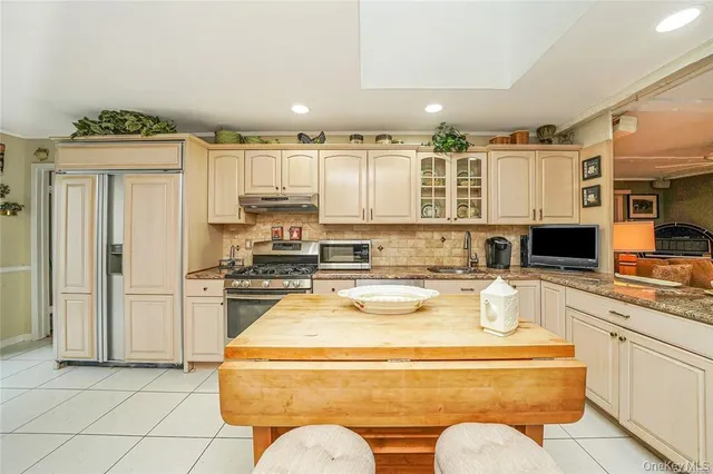 a kitchen with stainless steel appliances granite countertop a stove a sink and a refrigerator