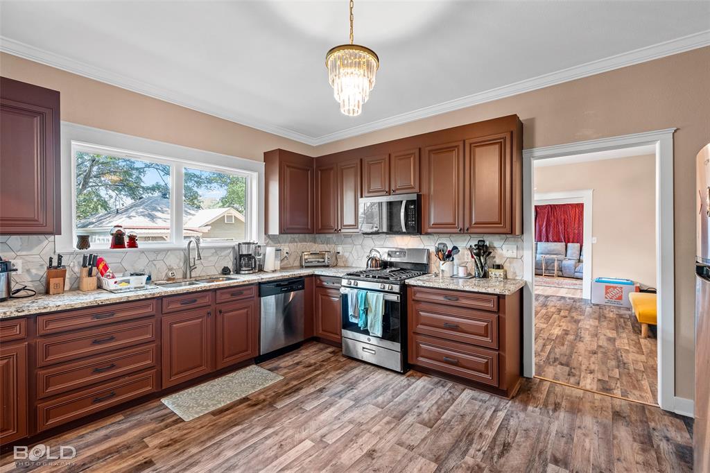 508 Chandler Street Minden, LA 71055 - Photo 19 of 35 a kitchen with stainless steel appliances granite countertop hardwood floor sink stove dining table and chairs