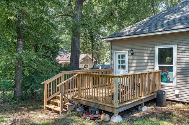 a backyard of a house with large trees and plants