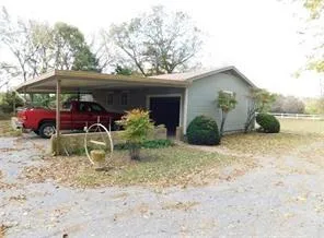 a view of house with a yard and plants