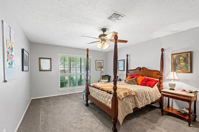 a bedroom with a bed a chandelier and dresser