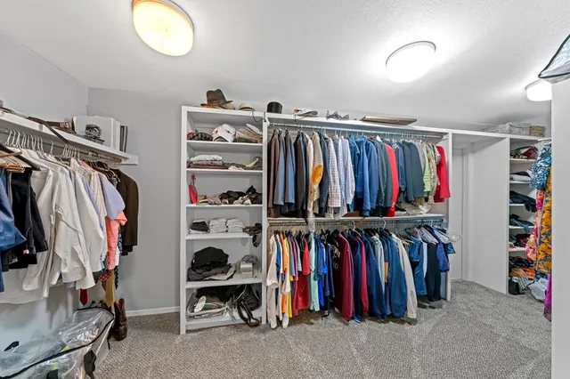 a view of walk in closet with clothes and shoes