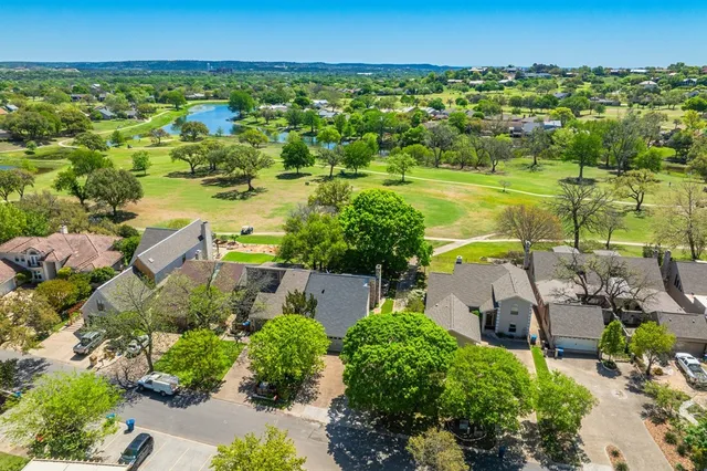 an aerial view of residential houses with outdoor space and swimming pool