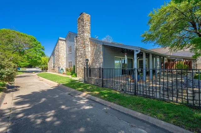 a view of a house with a yard and potted plants