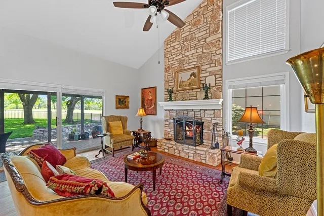 a living room with furniture fireplace and a large window
