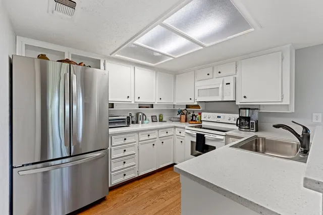a kitchen with white cabinets and stainless steel appliances