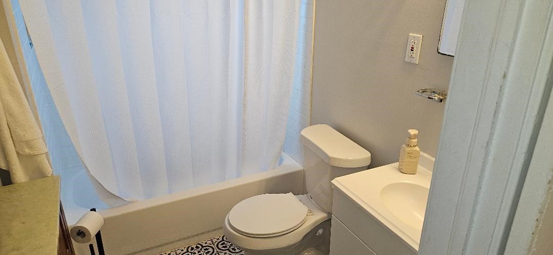 932 Walling Street Houston, TX 77009 - Photo 15 of 23 a white toilet sitting next to a shower curtain
