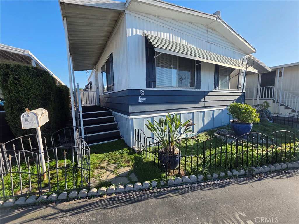 20806 Gridley Road, Unit 52 Lakewood, CA 90715 - Photo 20 of 51 a front view of a house with a garden