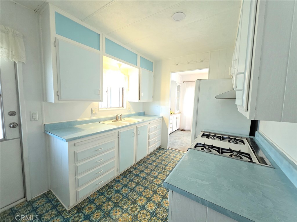 20806 Gridley Road, Unit 52 Lakewood, CA 90715 - Photo 27 of 51 a kitchen with a sink and a stove top oven
