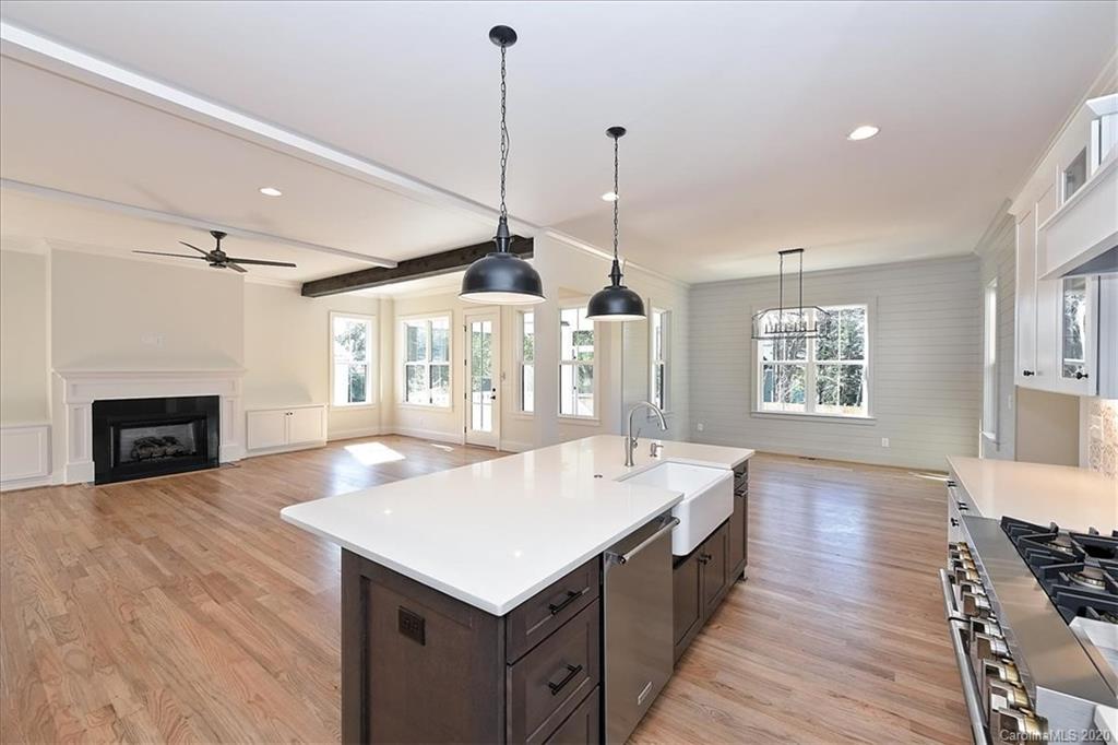 608 Marsh Road Charlotte, NC 28209 - Photo 11 of 31 a large kitchen with kitchen island a stove a sink a center island and wooden floor