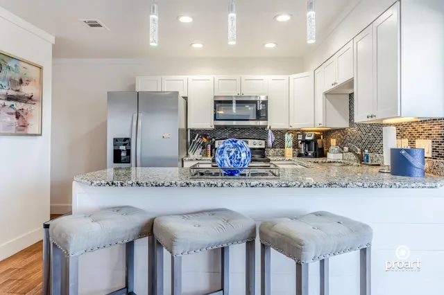 a kitchen with stainless steel appliances granite countertop a sink and a refrigerator