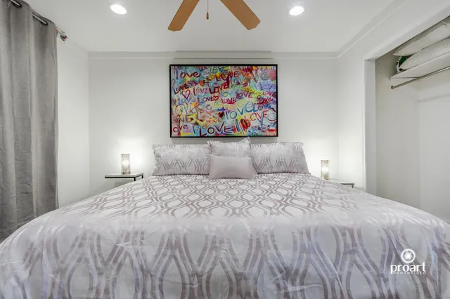 a bedroom with a bed and painting on the wall