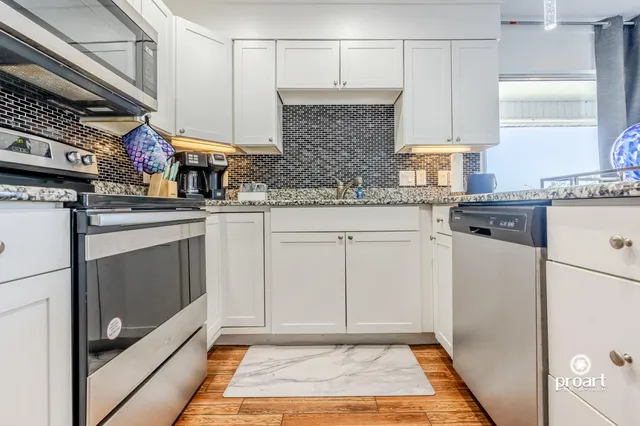 a kitchen with white cabinets and white appliances