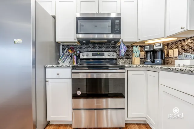 a kitchen with appliances a sink and cabinets