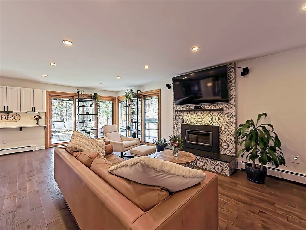 8 Fredrickson Road Norfolk, MA 02056 - Photo 18 of 39 a living room with furniture a fireplace and a flat screen tv