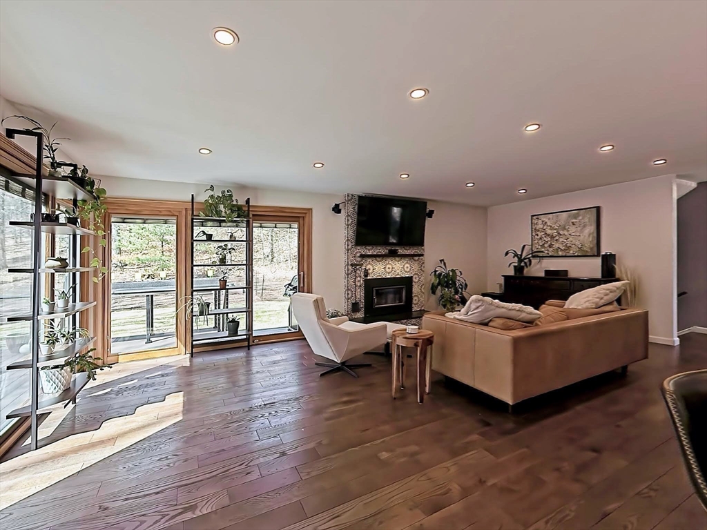 8 Fredrickson Road Norfolk, MA 02056 - Photo 21 of 39 a living room with furniture a fireplace and a flat screen tv