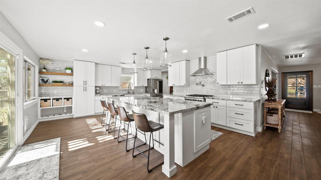 a kitchen with stainless steel appliances white cabinets sink and wooden floor