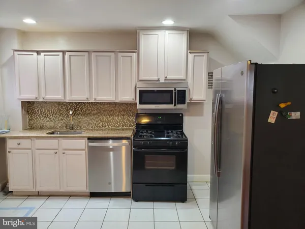 a kitchen with stainless steel appliances granite countertop a refrigerator and a stove