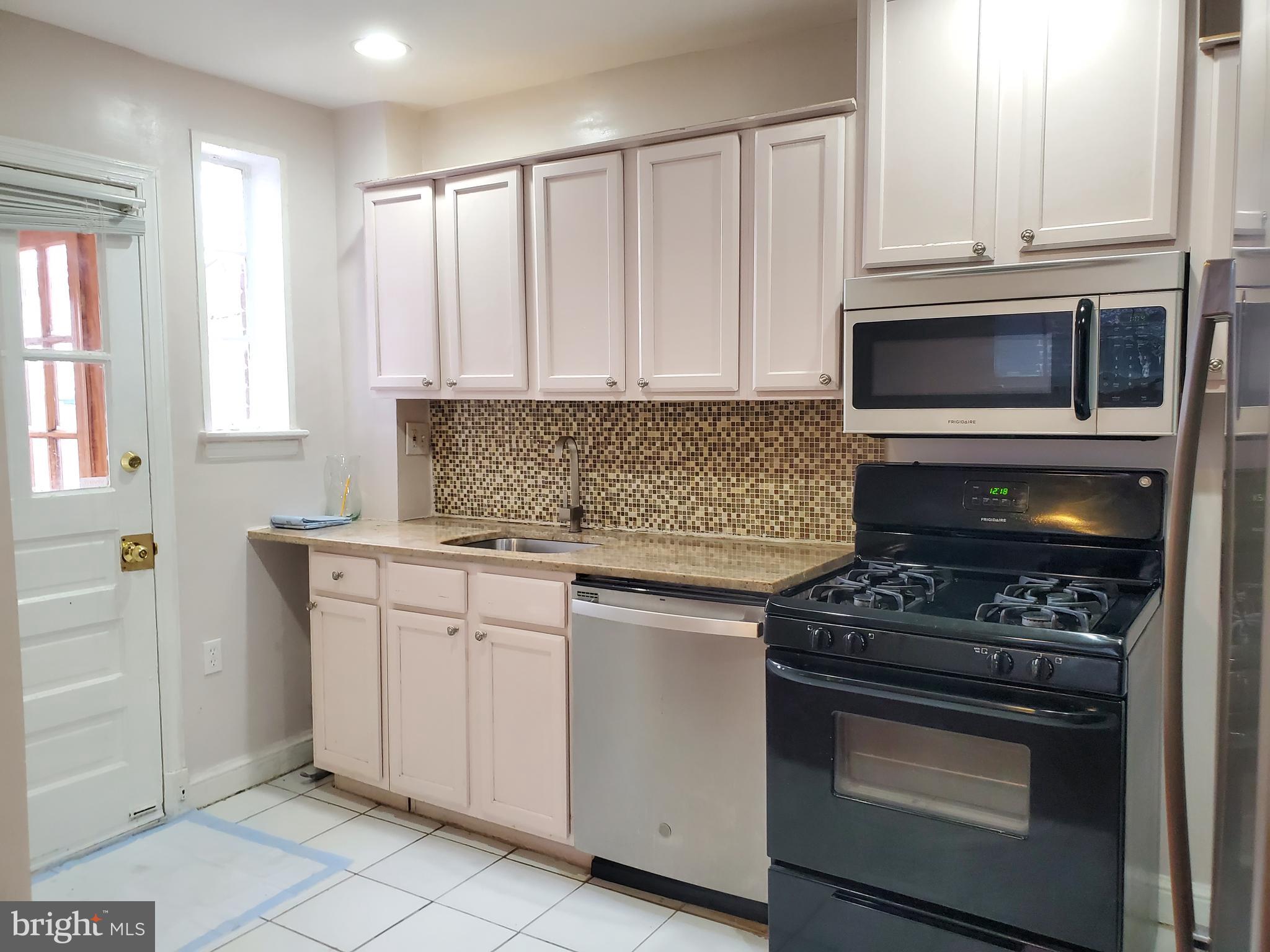 30 53rd Street Southeast Washington, DC 20019 - Photo 3 of 32 a kitchen with granite countertop white cabinets and stainless steel appliances
