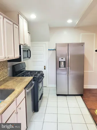 a kitchen with stainless steel appliances granite countertop a refrigerator and a stove