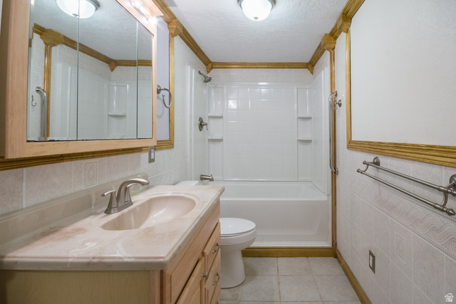 634 South 2100th Street West Vernal, UT 84078 - Photo 44 of 71 Bathroom featuring a vanity with an integrated sink, a medicine cabinet, a full bathtub with shower, and tiled walls and flooring