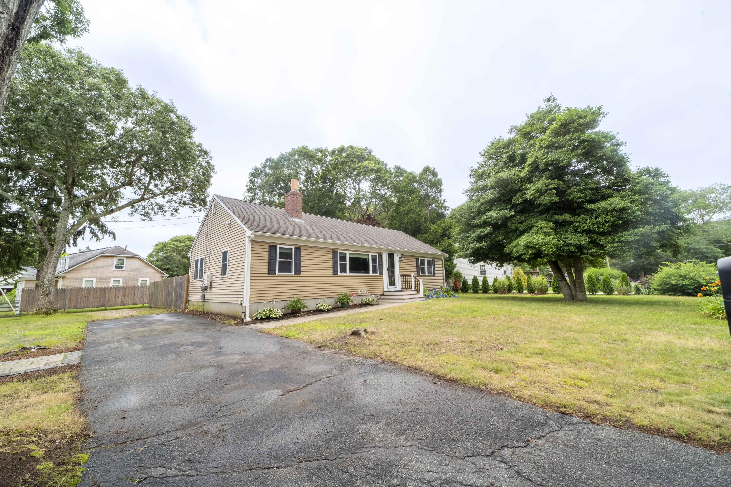 7 Arbeta Road Hyannis, MA 02601 - Photo 40 of 54 a front view of house with yard and trees in the background