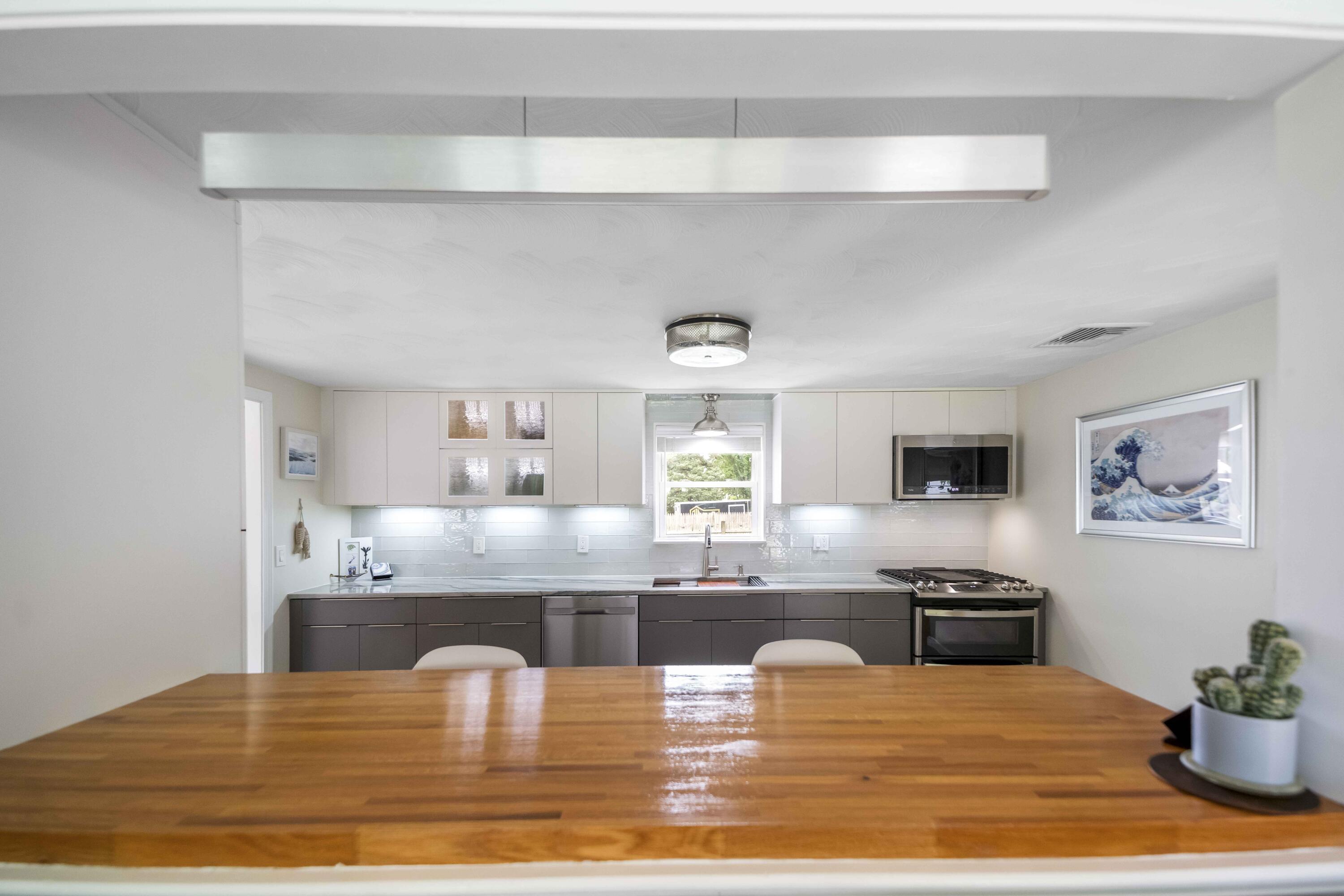 7 Arbeta Road Hyannis, MA 02601 - Photo 10 of 54 a kitchen with stainless steel appliances granite countertop a sink dishwasher and cabinets with wooden floor
