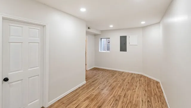 a view of an empty room with wooden floor