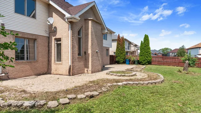 a view of a house with a yard and pathway