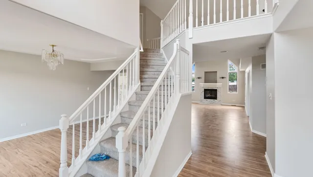 a view of staircase with white walls and wooden floor