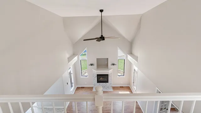 a view of a living room with a fireplace and ceiling fan