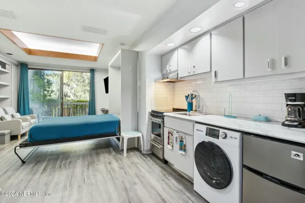 a view of a kitchen with furniture and wooden floor