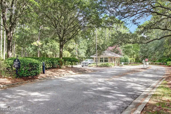 a view of a house with a yard and large trees