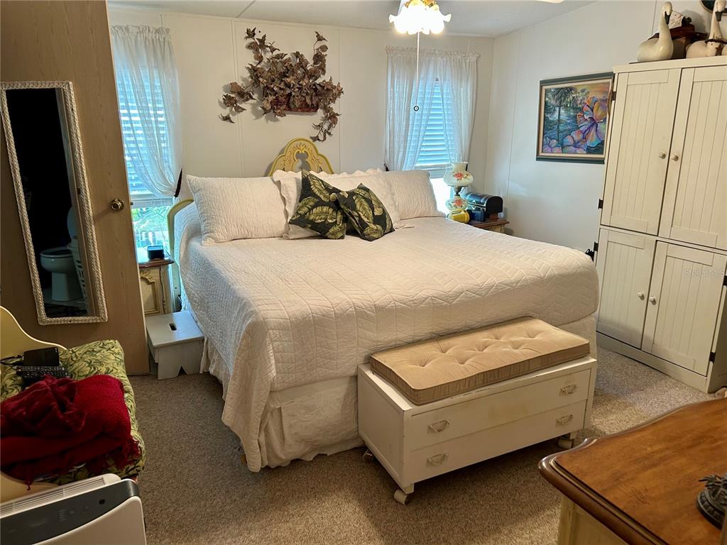 25646 Bass Road Astor, FL 32102 - Photo 12 of 48 a bedroom with a bed and a flat tv screen on dresser